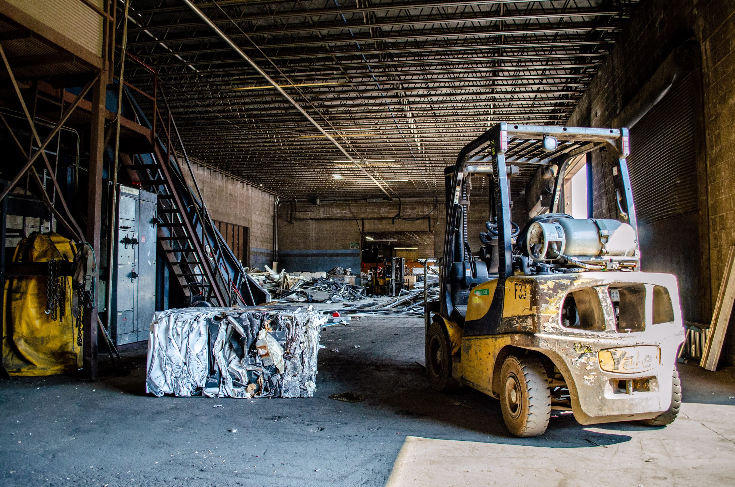 A forklift parked in a warehouse, ready for use.